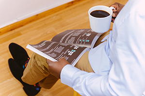 Man reading a magazine with coffee