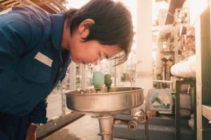 Worker washing their eyes at a decontamination station