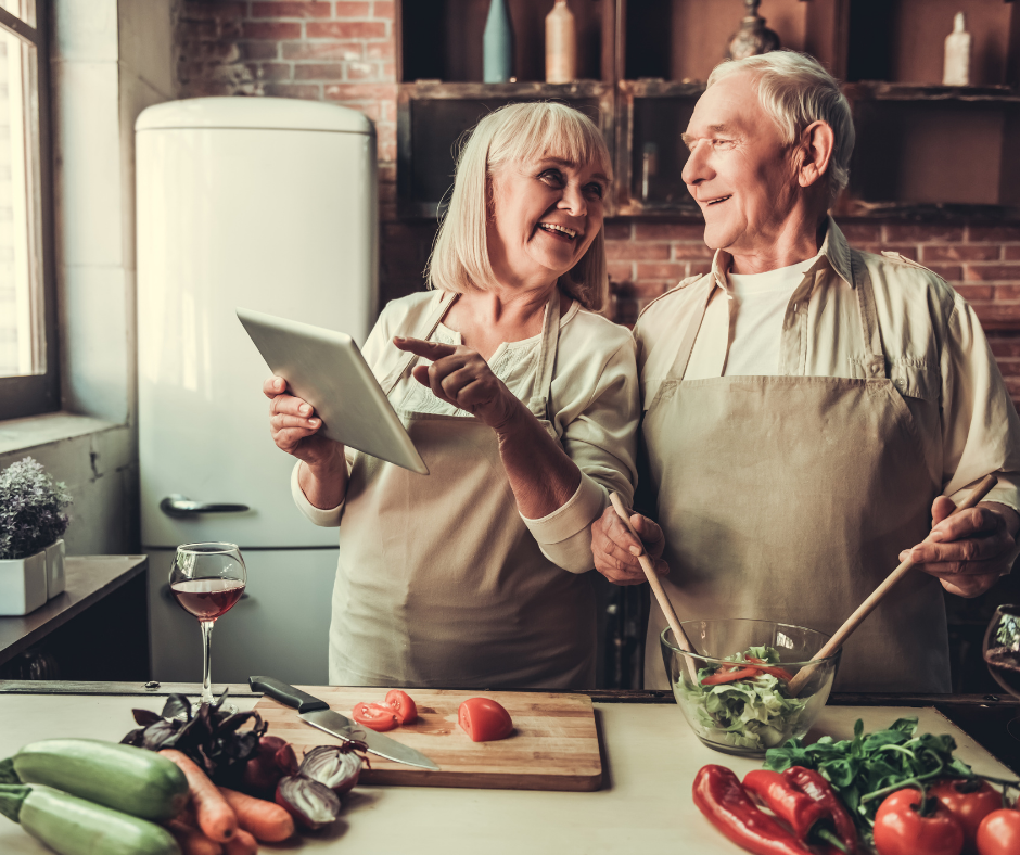 older couple cooking and laughing