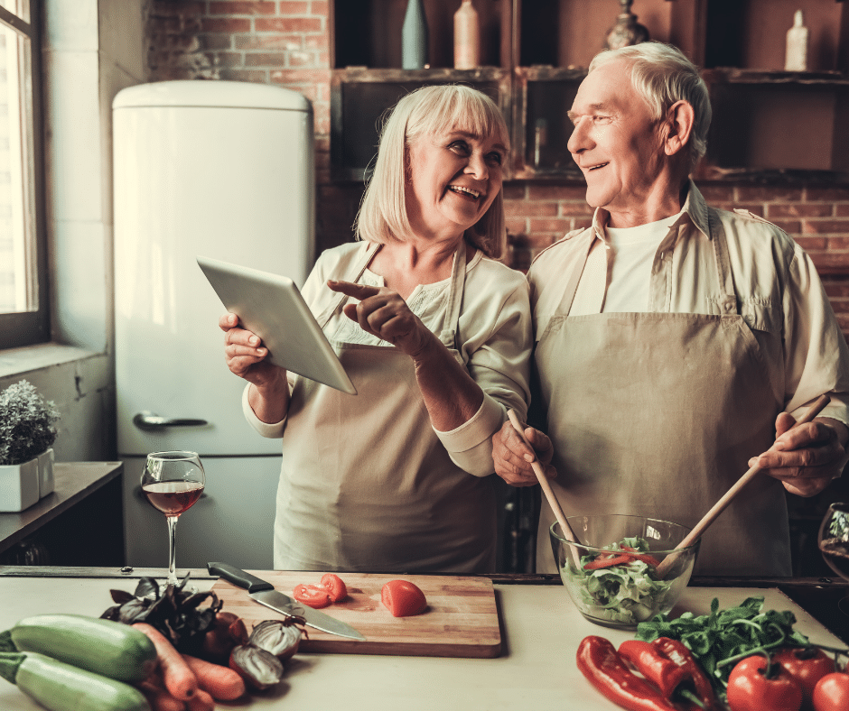 older couple cooking and laughing